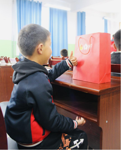 受赠小朋友对着礼物竖起大拇指。